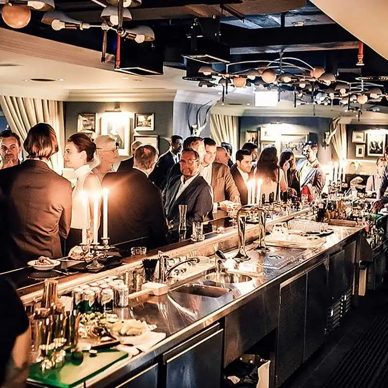 Guests socializing at a stylish bar, part of IconInk’s international hospitality management.