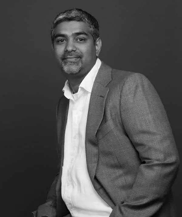 Maher Murshed – President of OHS Global Black and white portrait of Maher Murshed, President of OHS Global, wearing a checkered blazer and white dress shirt.